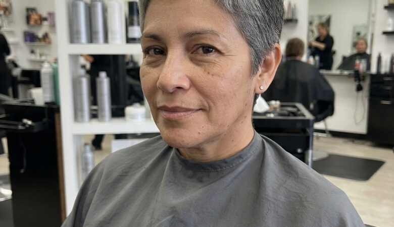 Layered silver-gray pixie cut with soft textured spikes and a neatly tapered back, styled for clean volume on mature hair